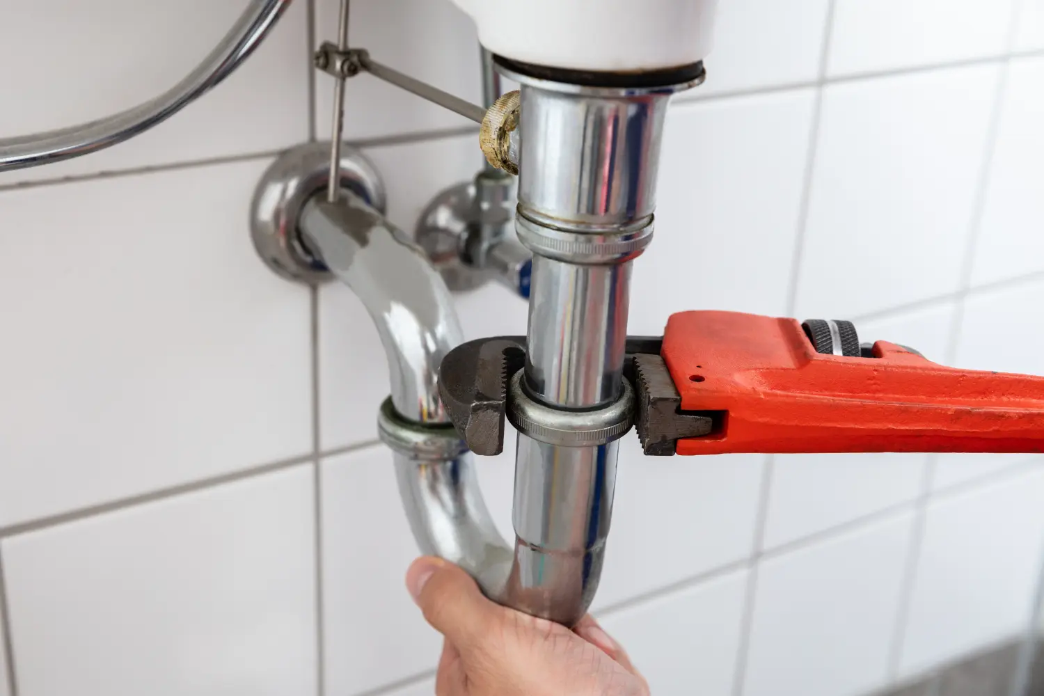 Klempner repariert Waschbecken mit verstellbarem Schraubenschlüssel